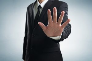 A security personnel holds out a hand signaling stop