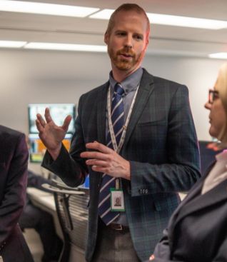 Redhead business man explaining a topic to people