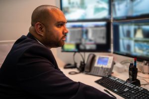 Security Guard watching Security Camera Footage on Screens