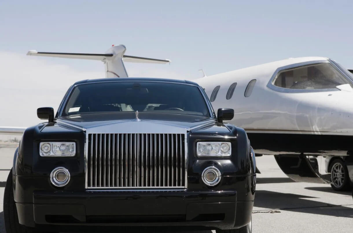 Car and private jet parked on a runway