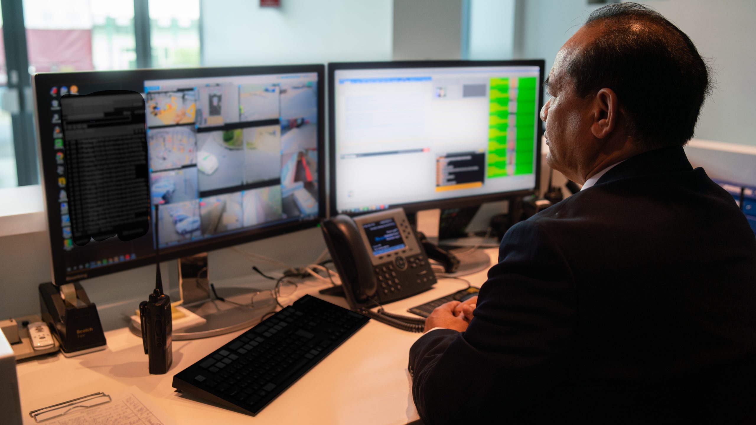 Security guards works on dual computer monitors