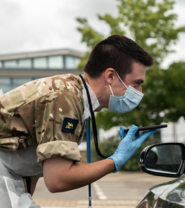 Ollie Woods (Museum Host / Infantry Soldier) looking into a car window with a mask and gloves on