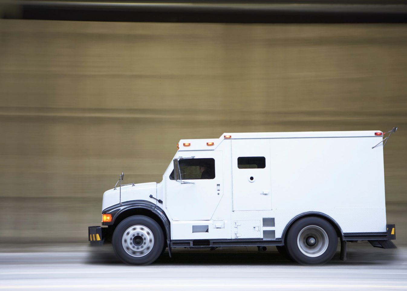 White security van driving on a road