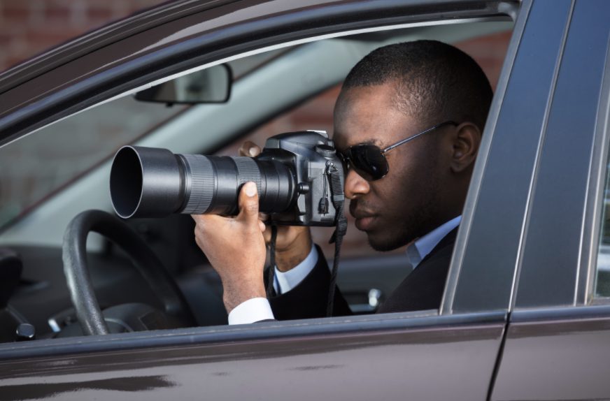 Security guard looks through a professional camera