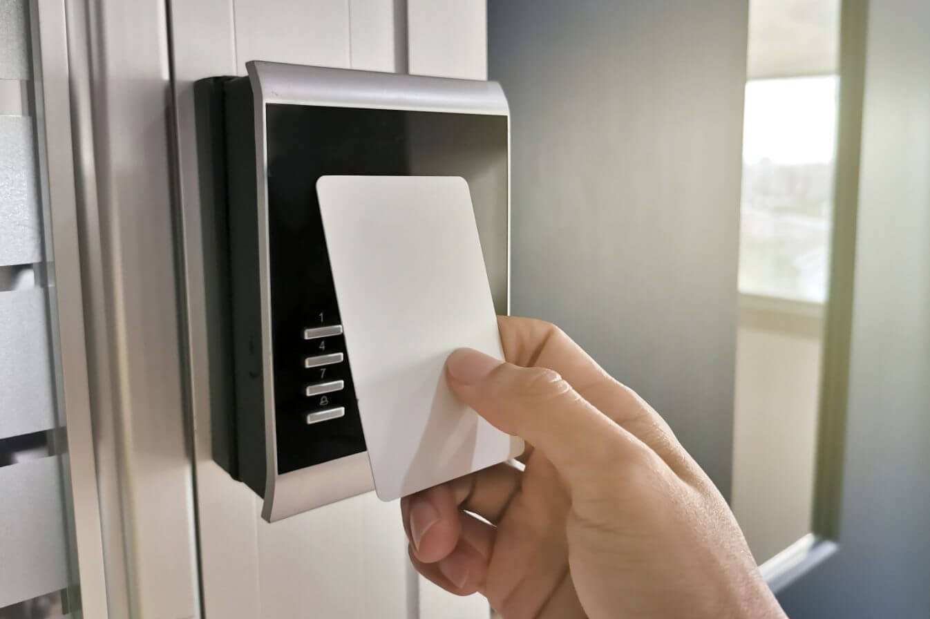 An electronic key taps an access control reader.