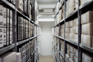 A long row of shelving with boxes sitting on the shelves