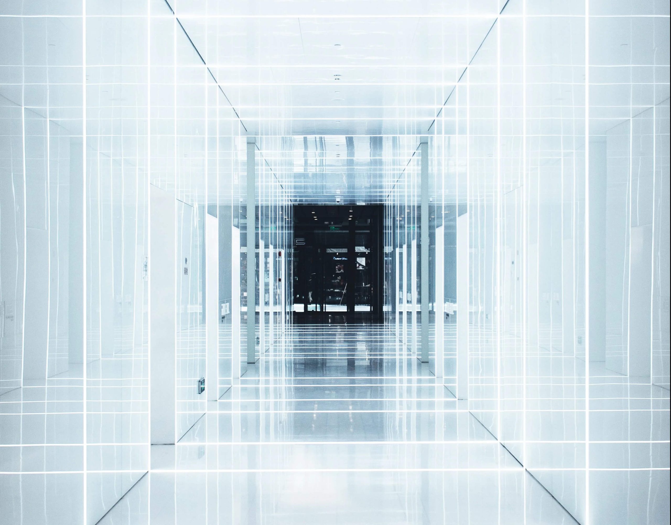 Lit hallway leading to a dark room