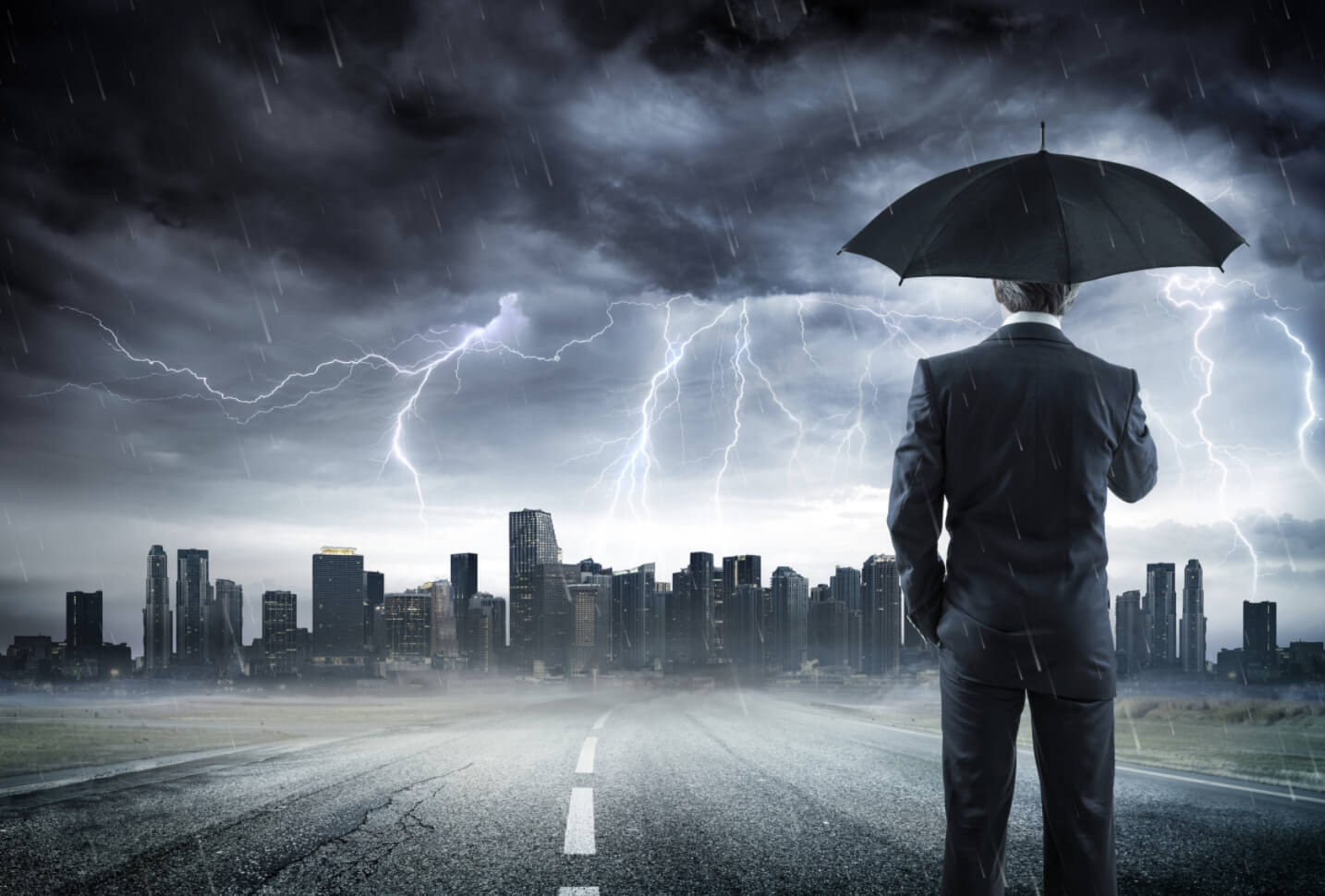Man with umbrella overlooks a city while a thunderstorm and lightning rage around him