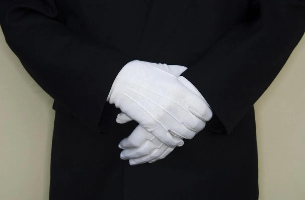 A close up view of the white-gloved hands of a professional residential security guard.
