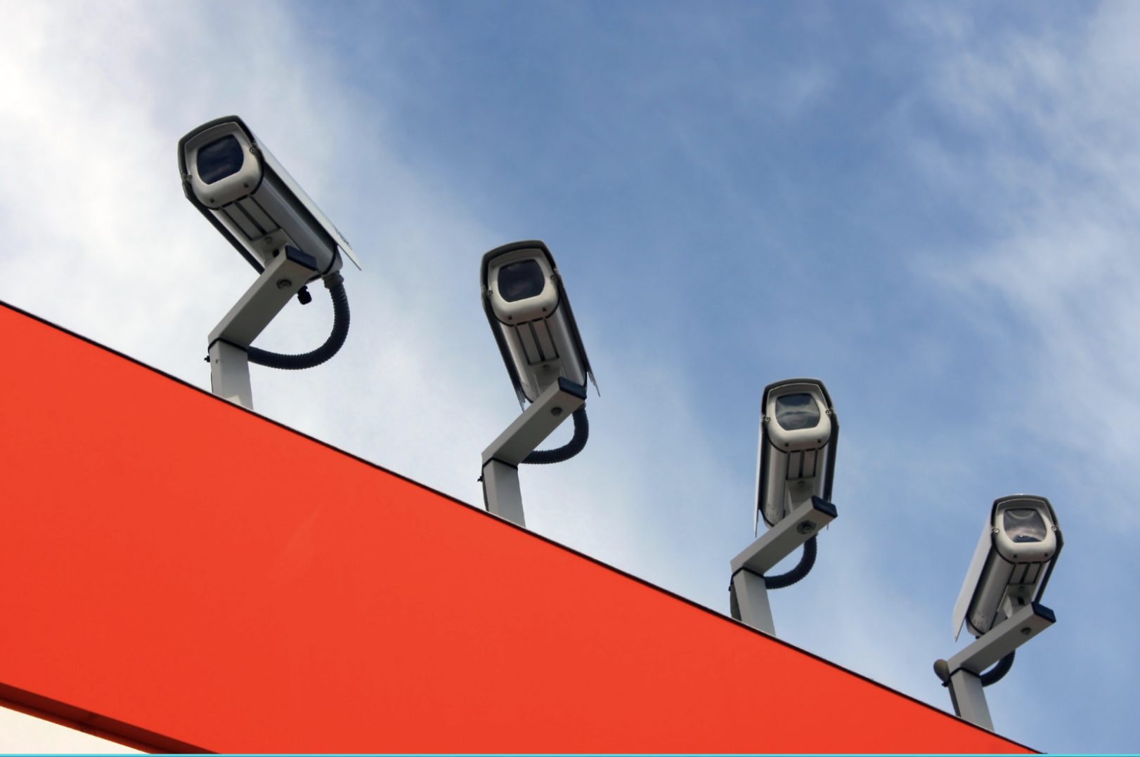Four security cameras overlook on top of a building