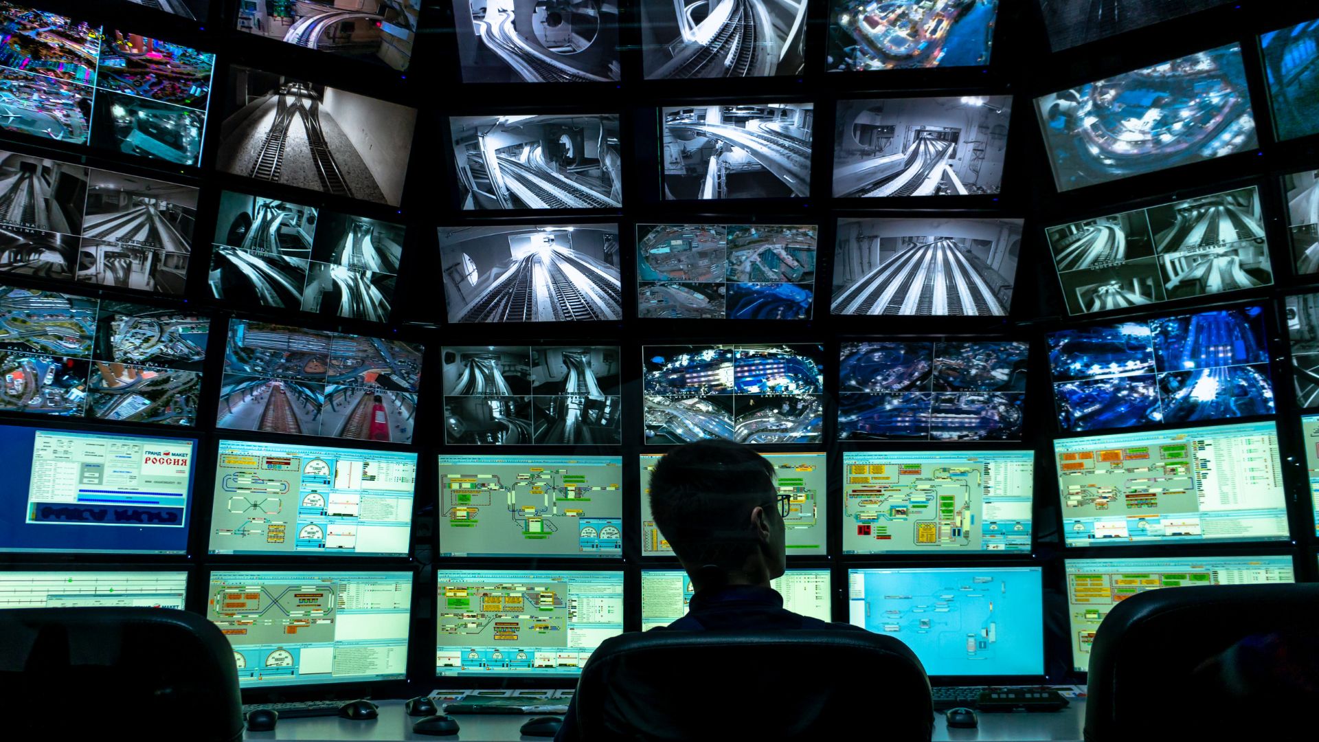 Man looks over several security screens